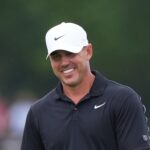 Brooks Koepka smiles while waiting to putt during the 2026 Byron Nelson golf tournament