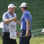 Harris English celebrates with his caddie on the 18th green during the Travelers Championship