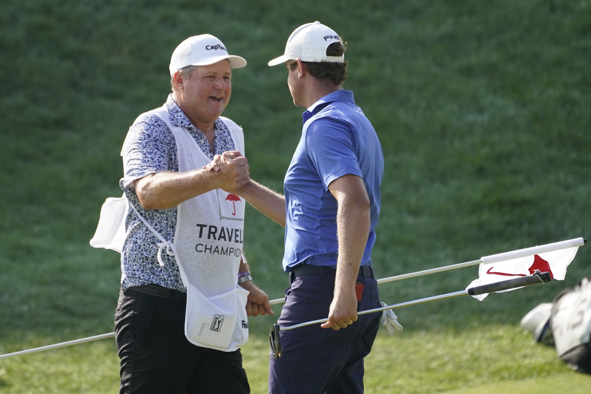Harris English celebrates with his caddie on the 18th green during the Travelers Championship