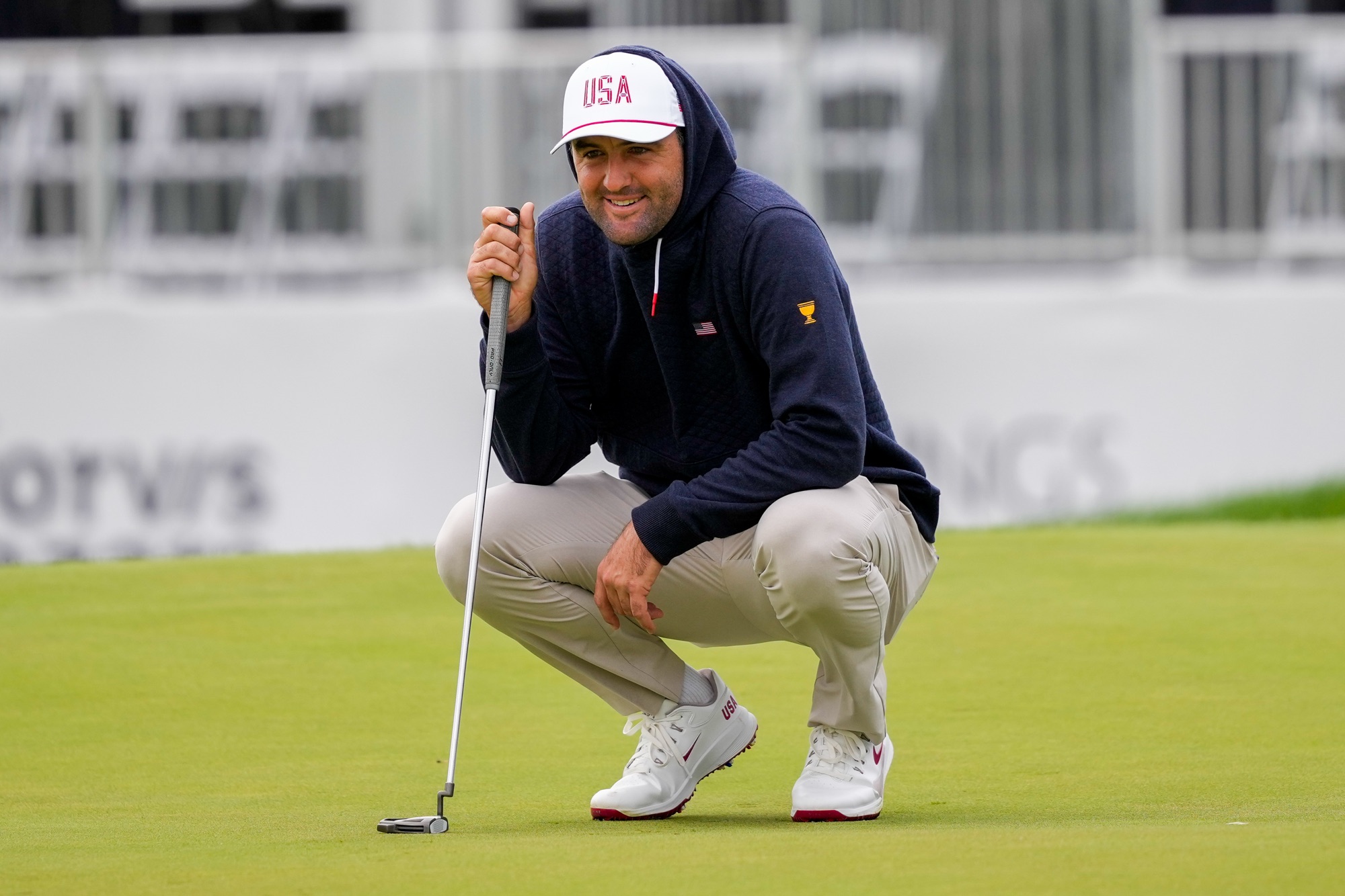 Scottie Scheffler crouches to read a putt on the 14th green during a Presidents Cup practice round at Medinah Country Club