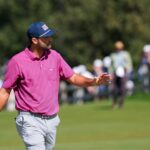 Scottie Scheffler waves on the third green during his Presidents Cup singles match at Medinah Country Club
