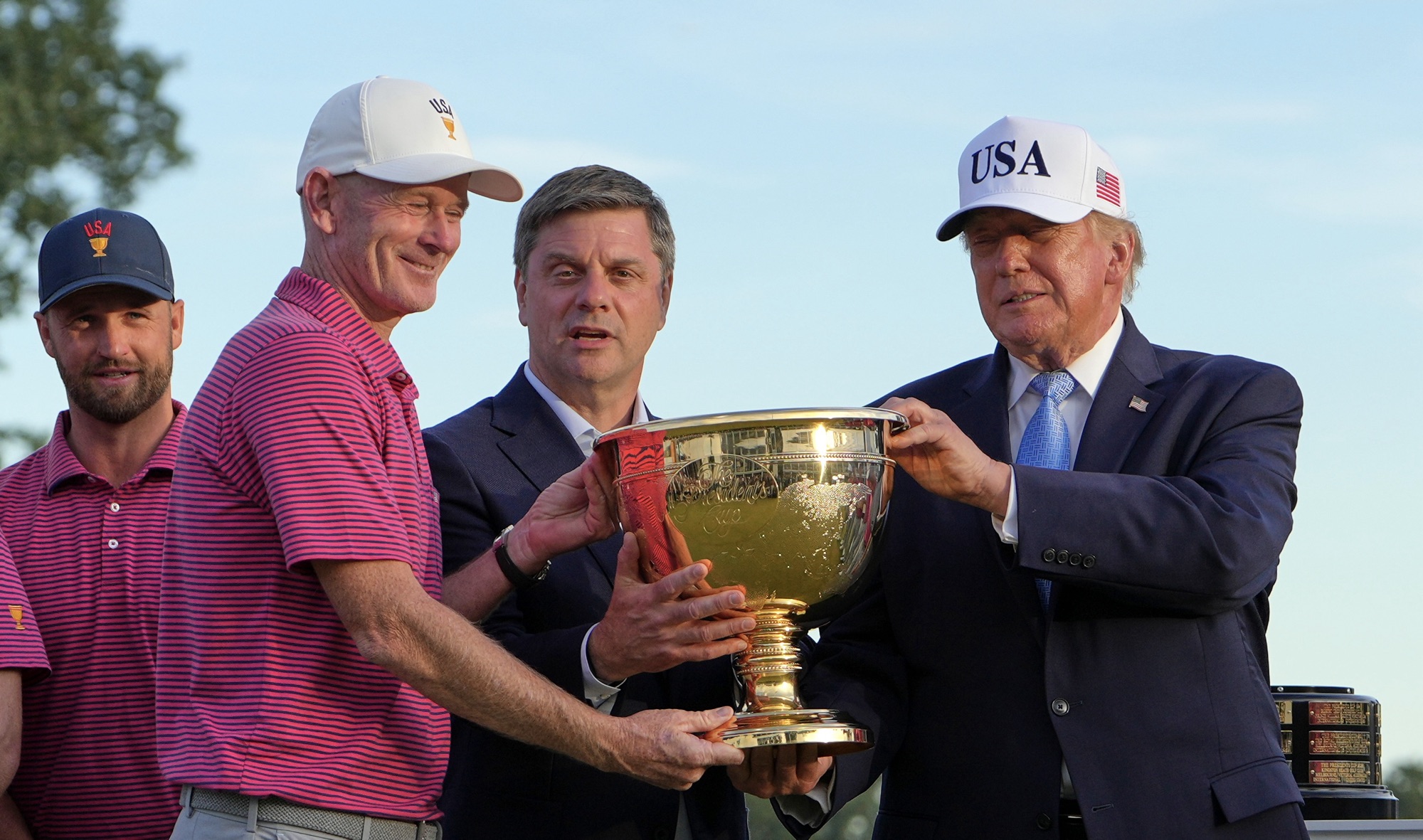 President Donald Trump and PGA Tour CEO Brian Rolapp hand the Presidents Cup trophy to U.S. captain Brandt Snedeker at Medinah Country Club