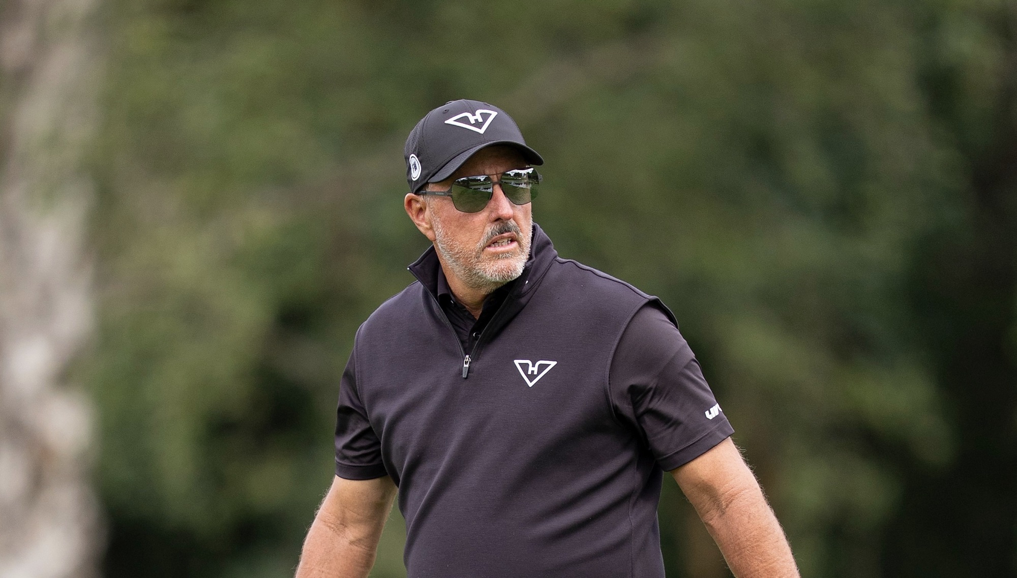 Phil Mickelson walks the first hole during the final round of LIV Golf's event at JCB Golf & Country Club in Rocester, England